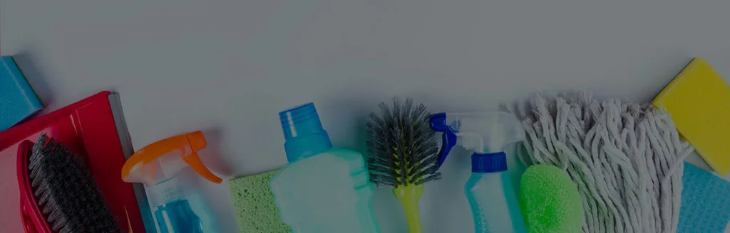 A team of cleaning professionals working in different cleaning areas. They wear uniforms and use specialized products to disinfect desks, glass, and floors. The environment looks impeccable and organized, conveying professionalism, hygiene, and a commitment to service quality.